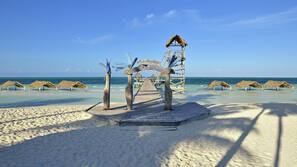 On the beach, white sand, sun-loungers, beach umbrellas
