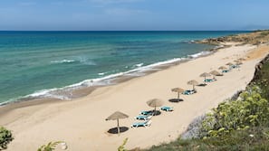 Praia particular, espreguiçadeiras, guarda-sóis