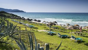 Praia particular, espreguiçadeiras, guarda-sóis