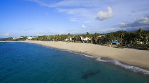 On the beach, white sand, sun loungers, beach umbrellas