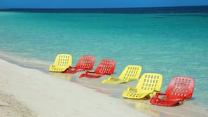 Sulla spiaggia, sabbia bianca, lettini da mare, ombrelloni