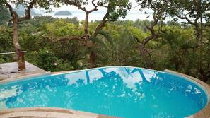 Una piscina al aire libre, tumbonas