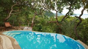Una piscina al aire libre, tumbonas