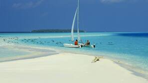 On the beach, white sand, sun loungers, beach umbrellas