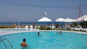 Piscine extérieure, parasols de plage, chaises longues