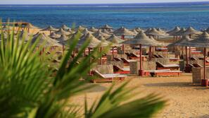 Sulla spiaggia, lettini da mare, ombrelloni, teli da spiaggia