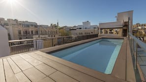 Una piscina al aire libre de temporada, tumbonas