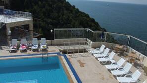 Piscine extérieure, parasols de plage, chaises longues