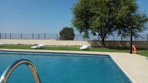 Una piscina al aire libre, tumbonas