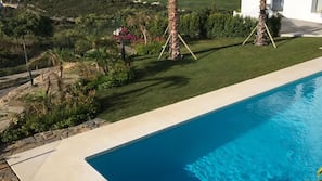 Una piscina al aire libre, sombrillas, tumbonas