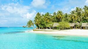 On the beach, white sand, sun-loungers, beach towels
