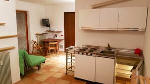 Frigorífico grande, placa de cocina y utensilios de cocina