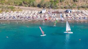 On the beach, black sand, sun loungers, beach umbrellas