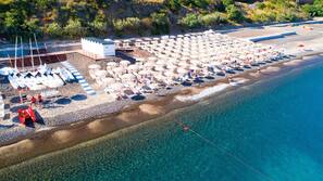 On the beach, black sand, sun loungers, beach umbrellas