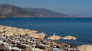 On the beach, black sand, sun loungers, beach umbrellas