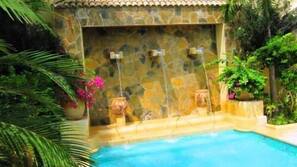 Una piscina al aire libre, una piscina con cascada