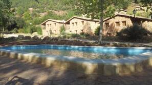 Una piscina al aire libre de temporada, tumbonas