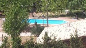 Una piscina al aire libre de temporada, tumbonas