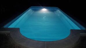 Una piscina al aire libre de temporada, tumbonas