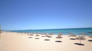 Playa privada y sombrillas