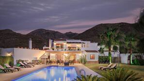Una piscina al aire libre, sombrillas, tumbonas