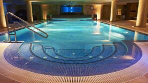 Una piscina cubierta, una piscina al aire libre, sombrillas, tumbonas