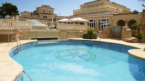 Una piscina cubierta, una piscina al aire libre, sombrillas, tumbonas