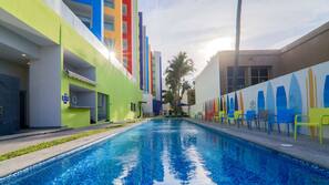 Una piscina al aire libre, sombrillas, tumbonas