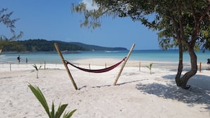 On the beach, white sand, sun-loungers, beach towels