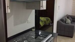 Frigorífico grande, microondas, placa de cocina y utensilios de cocina