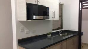 Frigorífico grande, microondas, placa de cocina y utensilios de cocina