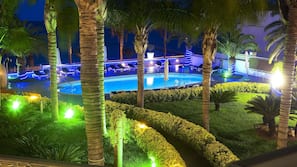 Una piscina al aire libre, sombrillas, tumbonas