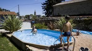 Una piscina al aire libre de temporada, sombrillas, tumbonas
