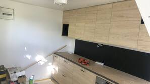 Een koelkast/vriezer, een magnetron, een oven, een kookplaat