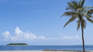 Am Strand, weißer Sandstrand, Liegestühle, Sonnenschirme