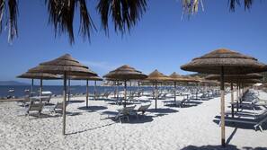 Sulla spiaggia, lettini da mare, ombrelloni
