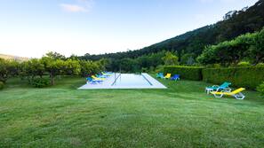 Una piscina al aire libre de temporada, sombrillas, tumbonas