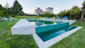 Una piscina al aire libre de temporada, sombrillas, tumbonas