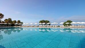 Piscine couverte, piscine extérieure, parasols de plage, chaises longues