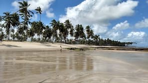 Na praia, areia branca, guarda-sóis, 5 bares na praia