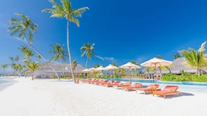 On the beach, white sand, sun-loungers, beach umbrellas