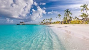 On the beach, white sand, sun-loungers, beach umbrellas