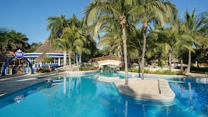 Una piscina al aire libre, sombrillas, tumbonas