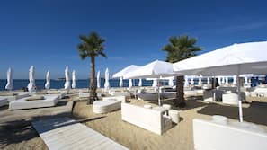 Sulla spiaggia, lettini da mare, ombrelloni