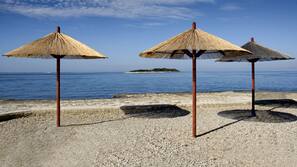 Sulla spiaggia, lettini da mare, ombrelloni