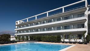 Una piscina al aire libre, sombrillas, tumbonas