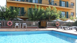 Una piscina al aire libre, tumbonas
