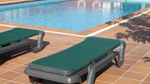 Una piscina al aire libre, tumbonas