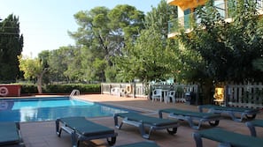 Una piscina al aire libre, tumbonas