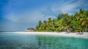 Plage privée, sable blanc, chaises longues, parasols